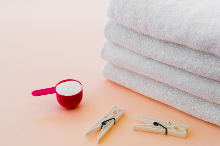 65d8bad8a8d981d8a7-1759683177 Close-up white folded clean towels with clothes pin فري بيك
