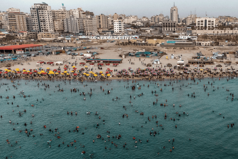 PALESTINIAN-GAZA-CLIMATE An aerial view shows Palestinians gathering on the beach in Gaza City on June 2, 2023, during a heat wave. (Photo by MOHAMMED ABED / AFP) (Photo by MOHAMMED ABED/AFP via Getty Images)