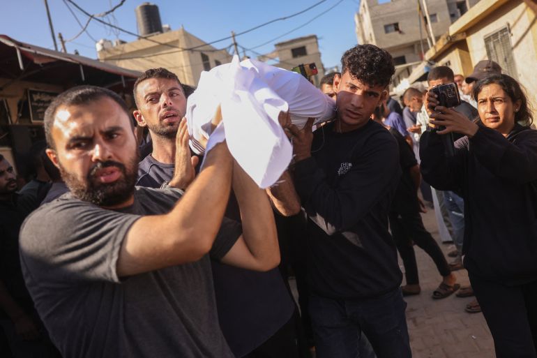 afp_68dcf21687f1-1759310358 Palestinians carry the body of a man killed in an Israeli strike, during a funeral procession outside al-Aqsa Martyrs hospital in Deir el-Balah in the central Gaza Strip, on October 1, 2025.
