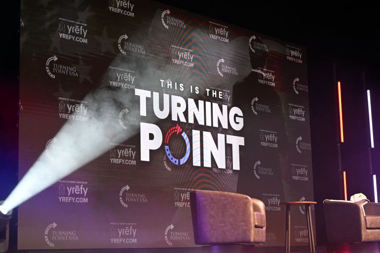 The Turning Point USA logo is seen on the stage during an "American Comeback Tour" stop in Burruss Hall at Virgina Tech university in Blacksburg, Virginia, on September 24, 2025.