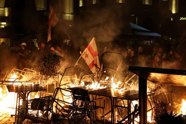 afp_68e17b927d24-1759607698 Protesters burn barricades as they clash with police during an opposition rally on the day of local elections in central Tbilisi on October 4, 2025. (Photo by GIORGI ARJEVANIDZE / AFP)