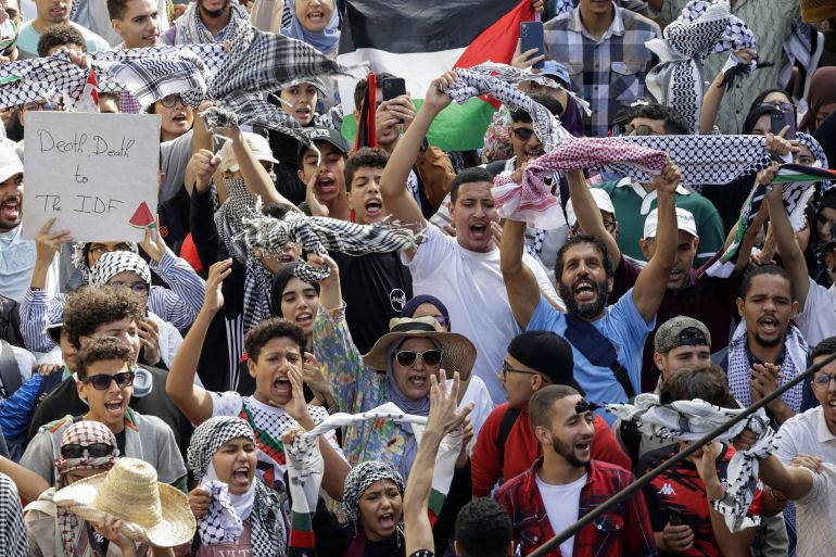 afp_68e27e333286-1759673907 Demonstrators lift flags of Palestine and placards during a march calling for an end to war in the Gaza Strip and protesting the normalization of relations between Morocco and Israel, on Mohammed V avenue in Rabat on October 5, 2025. (Photo by Abdel Majid BZIOUAT / AFP)