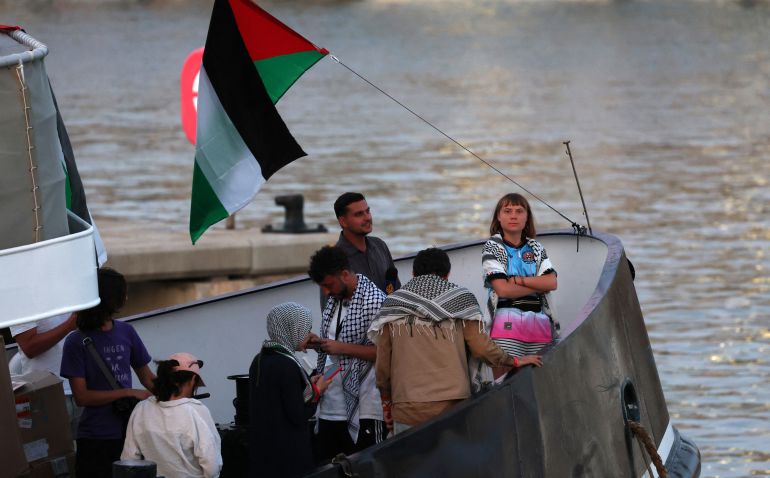 (FILES) Swedish climate activist Greta Thunberg (R) is seen on board of a vessel of a civilian flotilla, carrying pro-Palestinian activists, and humanitarian aid and aiming to break the Israeli blockade of the Gaza Strip, remains moored at Barcelona port on September 1, 2025, after being forced to return due to bad weather.