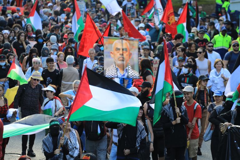 Demonstrators show Palestinian flags and a sign depicting Hamas' slain leader Yahya Sinwar during a march in Medellin, Colombia on October 7, 2025, on the second anniversary of the deadly Hamas-led attack on Israel which sparked a retaliatory offensive in Gaza.