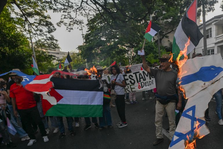 Demonstrators wave Palestinian flags and burn an Israeli flag during a march in Cali, Colombia on October 7, 2025, on the second anniversary of the deadly Hamas-led attack on Israel which sparked a retaliatory offensive in Gaza.