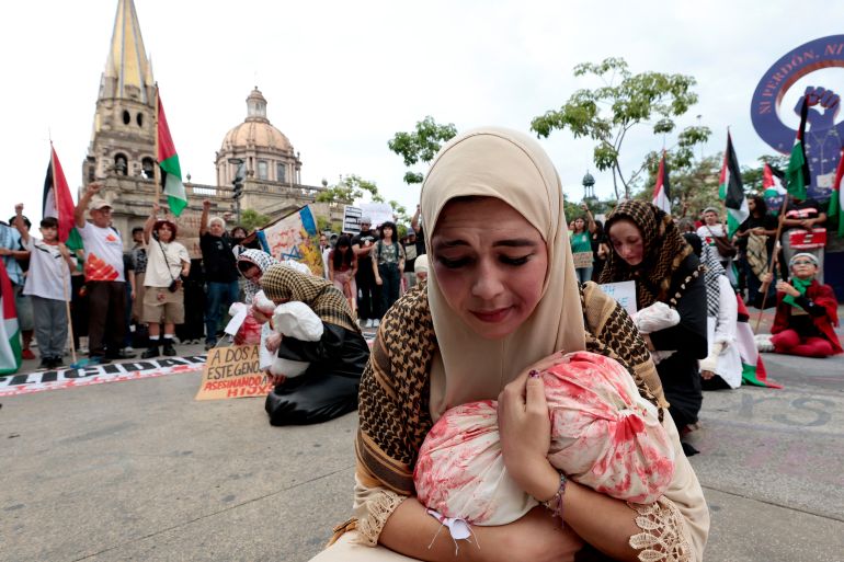 Women perform a piece about children killed in Gaza during a demonstration demanding an end to attacks on the Gaza Strip and Palestinian territories as part of a national protest in Guadalajara, Mexico on October 7, 2025.