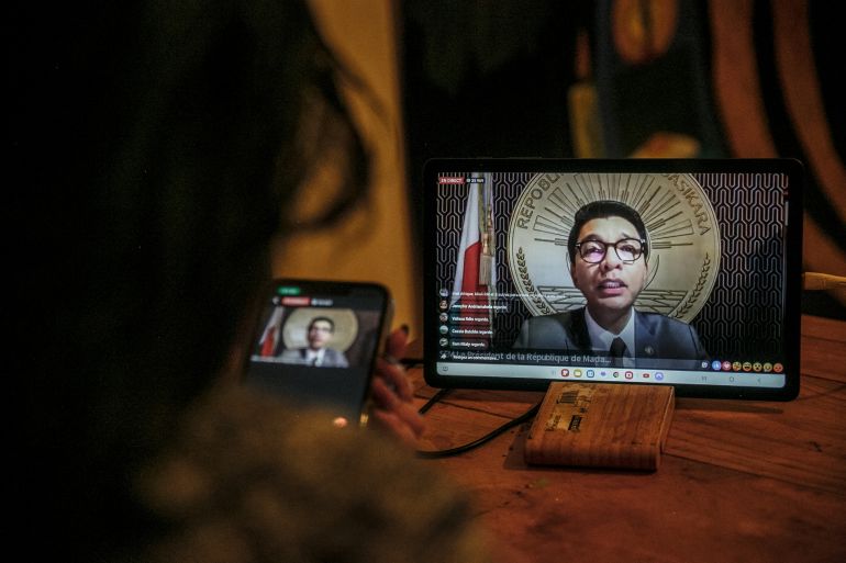afp_68ed7a69cfed-1760393833-2 A resident of Antananarivo watches Madagascar President Andry Rajoelina’s address to the nation via the official Facebook page of the Presidency of Madagascar, from her home in Antananarivo on October 13, 2025.