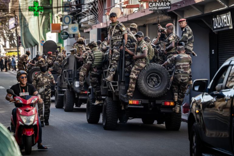 afp_68ee88753c9a-1760462965-1 Members of Madagascar’s Army CAPSAT unit ride on armoured vehicles as they head to the Presidential Palace in Antananarivo, October 14, 2025.