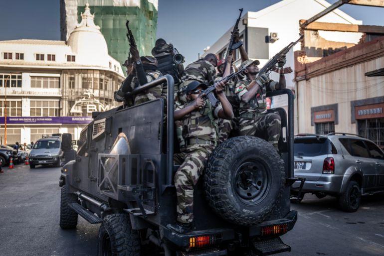 afp_68ef67408cda-1760520000 TOPSHOT - Members of Madagascar’s Army CAPSAT unit ride in armoured vehicles while assuming a defensive posture as they leave the Presidential Palace in Antananarivo, October 14, 2025.