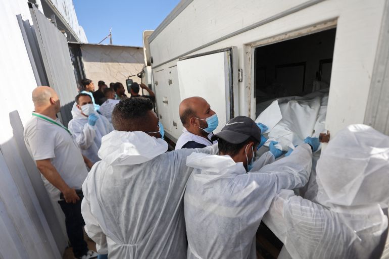 afp_68eff358e1b2-1760555864 Morgue workers unload the bodies of Palestinians that had been in Israeli custody, after they were transported by Red Crescent vehicles and refrigerated trucks, to the Nasser hospital in Khan Yunis in the southern Gaza Strip on October 15, 2025.