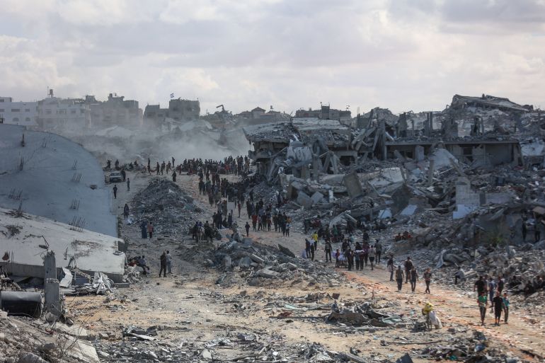 Palestinians search the rubble of buildings amid widespread destruction due to Israeli bombardment in Khan Yunis in the southern Gaza Strip, as a ceasefire holds on October 12, 2025.