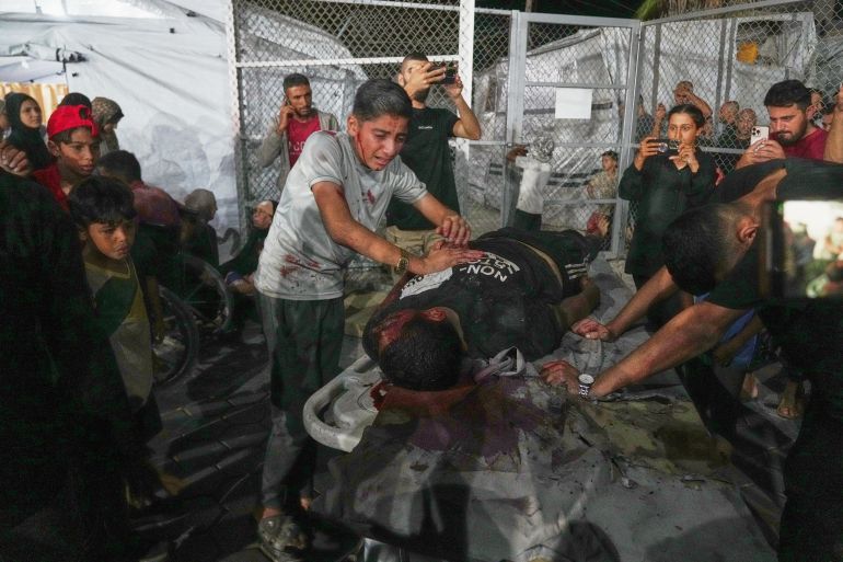 ap_68dcf1b097cac-1759310256 An injured boy mourns over the body of a man killed in an Israeli strike on a carpentry shop and a café as the victim is brought into Al-Aqsa Hospital in Deir al-Balah, in the central Gaza Strip, Tuesday, Sept. 30, 2025. (AP Photo/Abdel Kareem Hana)