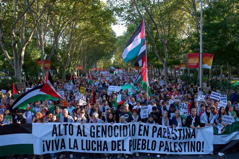 Pro-Palestinian demonstrators hold a banner reading: "Stop the genocide in Palestine, Long live the struggle of the Palestinian people," during a protest in Madrid, Spain, Saturday, Oct. 4, 2025. (AP Photo/Bernat Armangue)