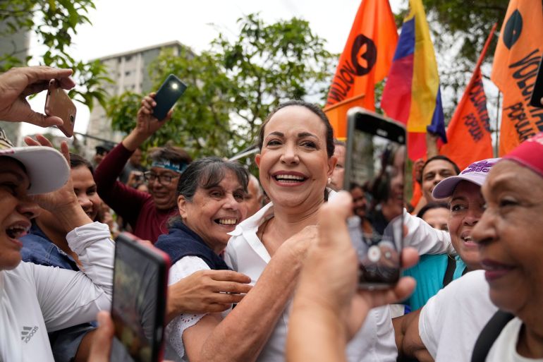 FILE - Opposition leader Maria Corina Machado is embraced by supporters during a rally where she asked them to keep the faith, in San Antonio, Venezuela, Wednesday, April 17, 2024. (AP Photo/Ariana Cubillos, File)