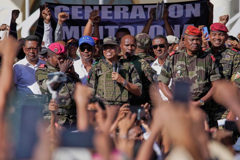 ap_68ee87a1af460-1760462753-1 CAPSAT military unit commander Col. Michael Randrianirina announces to protesters that the armed forces are taking control of the country in Antananarivo, Madagascar, Tuesday, Oct. 14, 2025. (AP Photo/Brian Inganga)