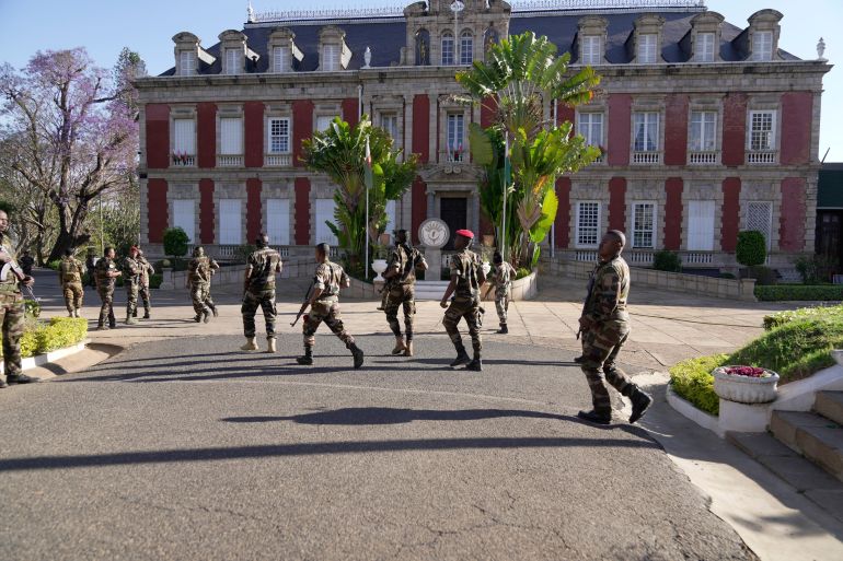 ap_68ef6e9fde189-1760521887 Troops loyal to CAPSAT military unit commander Col. Michael Randrianirina arrive at the presidency to announce that the armed forces are taking control of the country in Antananarivo, Madagascar, Tuesday, Oct. 14, 2025. (AP Photo/ Brian Inganga)