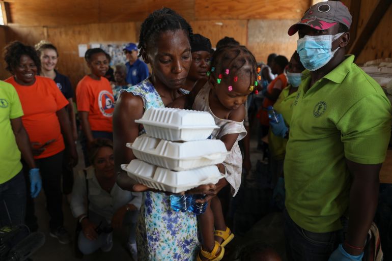 ap_68efa8b58d97a-1760536757 FILE - A woman carrying a child walks away with food from the World Food Program (WFP) at the Jean Marie Vincent High School whish has been turned into a shelter for families displaced by gang violence in the Tabarre neighborhood of Port-au-Prince, Haiti, Thursday, July 25, 2024. (AP Photo/Odelyn Joseph, File)