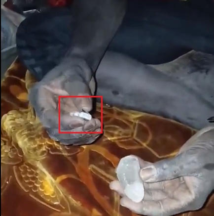 الشاب يضغط بإبهامه على زر جانبي في اللحظة نفسها التي يلامس فيها القطعة البلورية،