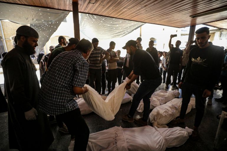 epa_68f49239e12e-1760858681 epa12462101 Palestinian relatives of the Abu Shaban family stand around the bodies of their loved ones at Al Ahli Baptist Hospital in Gaza City, 18 October 2025. At least eleven members of the Abu Shaban family were killed a day earlier when their car was hit by an Israeli army strike in the Al Zaitun neighbourhood, east of Gaza City. EPA/MOHAMMED SABER