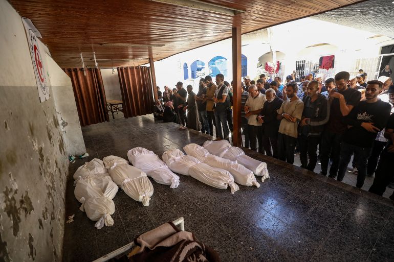 epa_68f4cc01b950-1760873473 epa12462098 Palestinian relatives of the Abu Shaban family pray beside the bodies of their loved ones at Al Ahli Baptist Hospital in Gaza City, Palestine, 18 October 2025. At least eleven members of the Abu Shaban family were killed a day earlier when their car was hit by an Israeli army strike in the Al Zaitun neighbourhood, east of Gaza City. EPA/MOHAMMED SABER