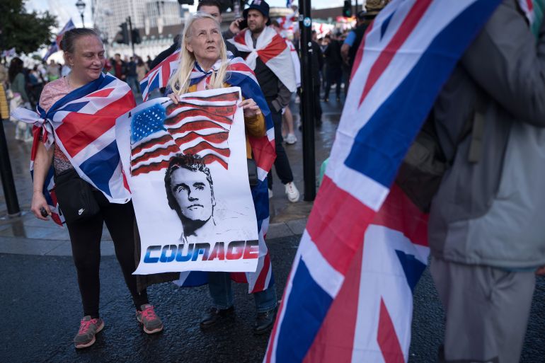 LONDON, ENGLAND - SEPTEMBER 13: Protesters carry a poster depicting the late US political activist Charlie Kirk during the "Unite The Kingdom" rally on Westminster Bridge by the Houses of Parliament on September 13, 2025 in London, England. Far-right activist Tommy Robinson (also known as Stephen Yaxley-Lennon) has invited supporters to hold a rally in central London entitled "Unite The Kingdom". The former English Defence League leader and his supporters are actively islamophobic and racist and have been behind much of the unrest seen outside hotels housing migrants this summer. Stand Up To Racism are mounting a counter-protest to today's rally. (Photo by Christopher Furlong/Getty Images)