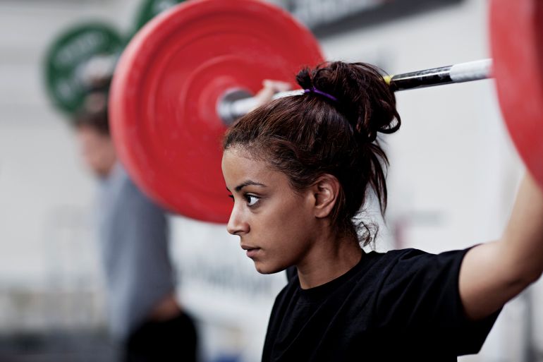 gettyimages-147486773-1760720890 Young woman training with weights - stock photo