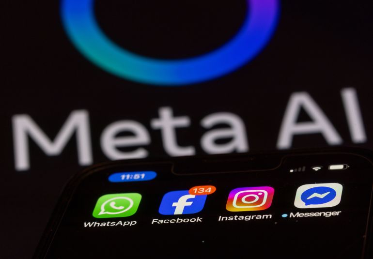 ILLUSTRATION - 27 May 2025, Mecklenburg-Western Pomerania, Schwerin: The Facebook, Messenger, Instagram and WhatsApp apps are shown on a smartphone display, with a monitor with the logo of the AI application Meta AI in the background. The Facebook group Meta can now start training its artificial intelligence systems on a large scale with user data from Germany. Photo: Jens Büttner/dpa (Photo by Jens Büttner/picture alliance via Getty Images)