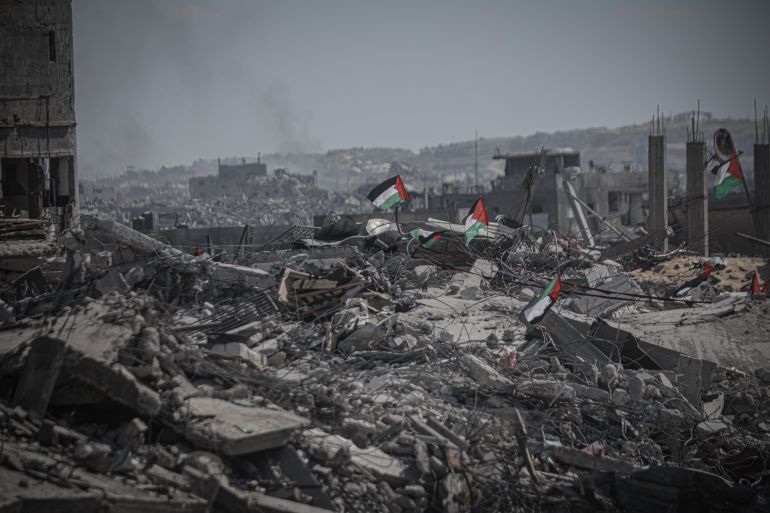 gettyimages-2240478337-1760970784 GAZA CITY, GAZA - OCTOBER 13: Palestinian flags are seen among the rubble of destroyed buildings as residents continue to return to northern Gaza following the ceasefire and the withdrawal of Israeli forces on October 13, 2025. (Photo by Ahmed Jihad Ibrahim Al-arini/Anadolu via Getty Images)