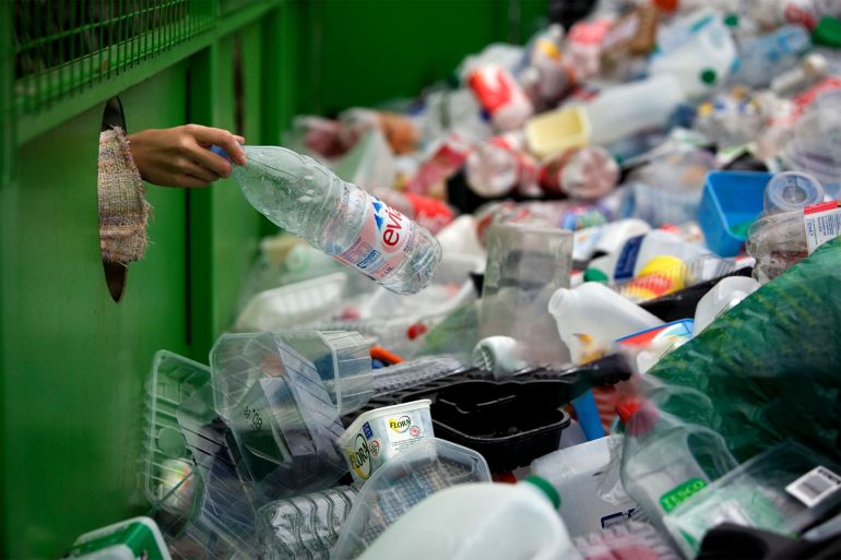 Recycling Plastic A woman depositing a plastic bottle in a recycling bin in Worcestershire, UK. gettyimages-522156604