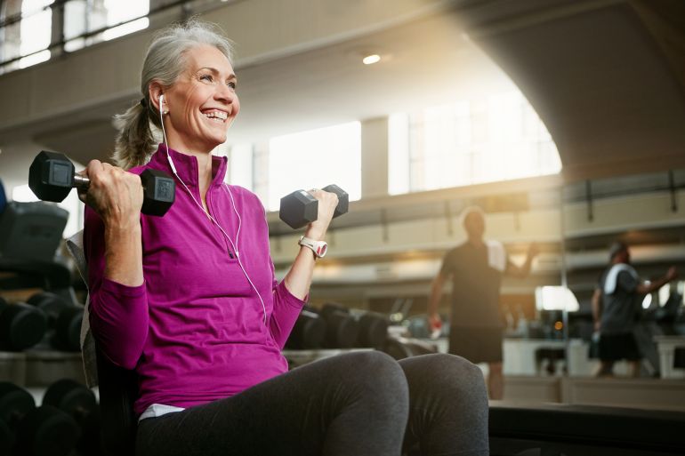 gettyimages-700614430-1760720883 Portrait of a happy senior woman working out with weights at the gym