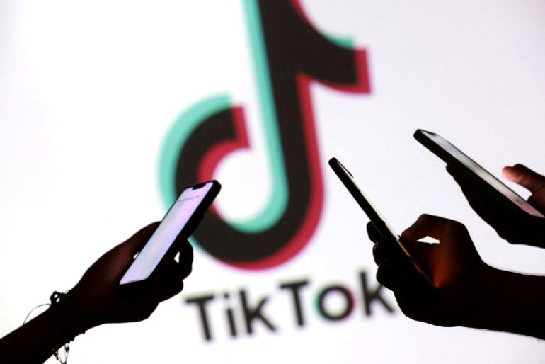 reuters_68de466e-1759397486 FILE PHOTO: Teenagers pose for a photo while holding smartphones in front of a TikTok logo in this illustration taken September 11, 2025. REUTERS/Dado Ruvic/Illustration/File Photo