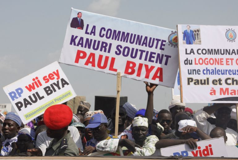 Supporters of Cameroon's 92-year-old President Paul Biya, who is seeking an eighth term, hold signs during the launch of his electoral campaign, in Maroua, Cameroon, October 7, 2025. Sign in the center reads "The Kanuri community supports Paul Biya". REUTERS/Desire Danga Essigue