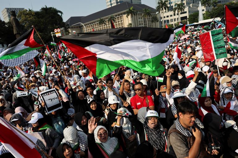 reuters_68eb56dd-1760253661 People wave Palestinian flags during a rally in support of Palestinians in Gaza, after a ceasefire between Israel and Hamas in Gaza went into effect, in Jakarta, Indonesia, October 12, 2025. REUTERS/Willy Kurniawan
