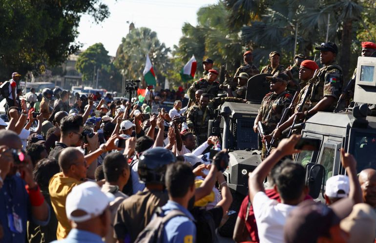reuters_68ef6785-1760520069 Members of the military look on as they leave after joining protesters gathered outside the town hall on Independence Avenue during a nationwide youth-led demonstration against frequent power outages and water shortages, in Antananarivo, Madagascar, October 14, 2025. REUTERS/Siphiwe Sibeko