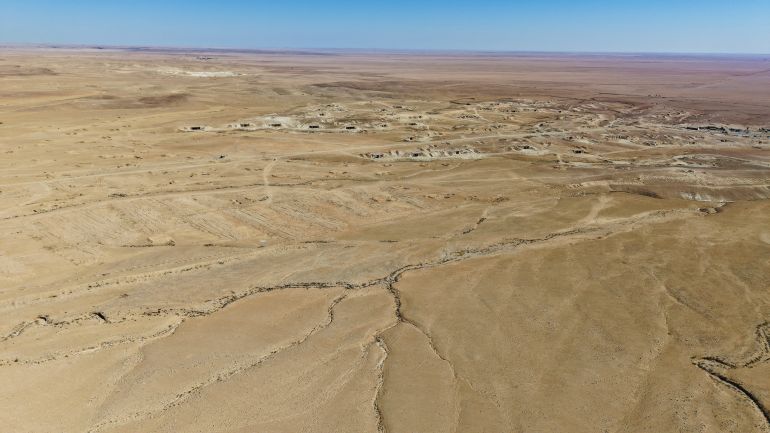 reuters_68f2637f-1760715647 A drone view of the mass grave site in the desert near the town of Dhumair, Syria, February 27, 2025. A Reuters investigation found that the Assad government secretly trucked thousands of bodies to the site. REUTERS/Khalil Ashawi To match Special Report SYRIA-SECURITY/MASS GRAVES