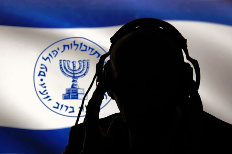 A dark silhouette of a man with headphones listening, Israeli intelligence, spy and special agent, the Israeli flag of the special services. Hebrew inscription, menorah Image, selective focus.