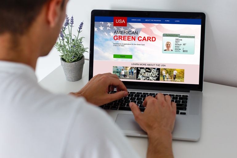 man with laptop with United States Permanent Resident Card website; Shutterstock ID 2042721767; purchase_order: aj; job: ; client: ; other: