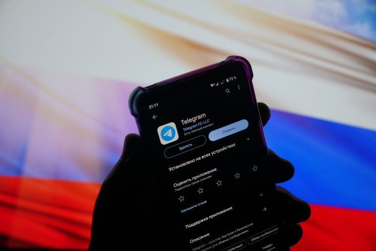 The smartphone display with the Telegram messenger logo on the background of the Russian flag. May 4, 2024, Moscow, Russia.