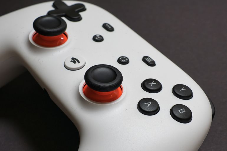 Zurich, Switzerland - March 07, 2021: Close up of white video game controller for Google Stadia, against black background.