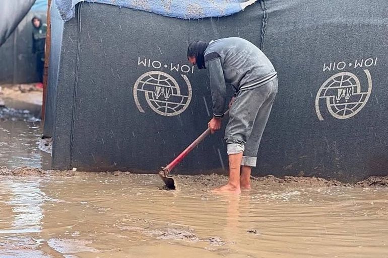 لاجئ في غزة يحاول إبعاد المياه عن خيمته (قناة ملاحم القسام على تلغرام)