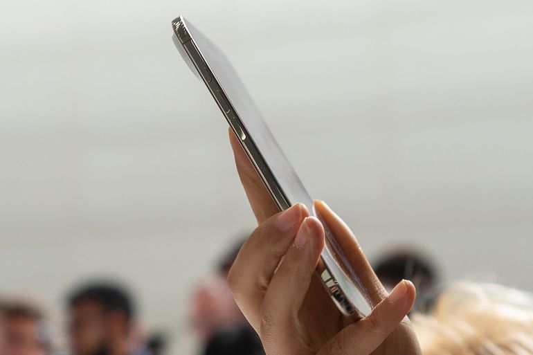 09 September 2025, USA, Cupertino: A participant at the presentation of new iPhone models from Apple tries out the new thinner iPhone Air. Photo: Andrej Sokolow/dpa (Photo by Andrej Sokolow/picture alliance via Getty Images)