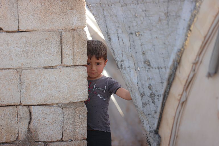 IDLIB, SYRIA - MARCH 27: Children living in tent camps play on the street as thousands of civilians, who were displaced due to the attacks of the ousted Bashar al-Assad regime and its supporters, are welcoming Eid al-Fitr away from their homes due to financial difficulties despite the fall of the regime in Idlib, Syria on March 27, 2025. Civilians who were displaced from their homes in different provinces of Syria due to the ousted regime attacks and are now struggling to survive in makeshift tent camps are entering another Eid al-Fitr with bitterness due to poverty and high prices. (Photo by Izettin Kasim/Anadolu via Getty Images)