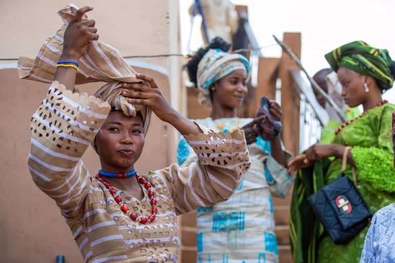 afp_6906fd279b1a-1762065703 A bride ties her head gear, before the Awon mass wedding in Shao, Kwara State, on October 31, 2025.