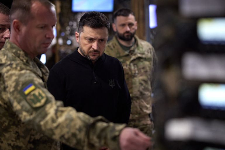afp_6915e63893e1-1763042872 This handout photograph taken and released by Ukrainian Presidential Press-service on November 13, 2025 shows the President Volodymyr Zelensky (C) and servicemen looking at a map during his visit in 65th Separate Motorized Brigade in Zaporizhzhia region, amid Russian invasion in Ukraine.