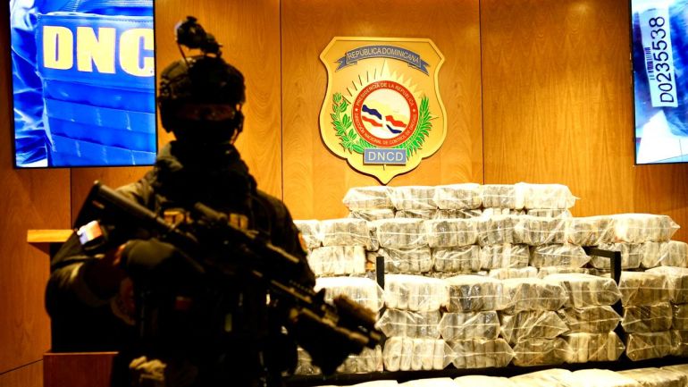 Handout picture released by the National Drug Control Directorate (DNCD) shows a police officer next to alleged cocaine packs in Santo Domingo on November 15, 2025.