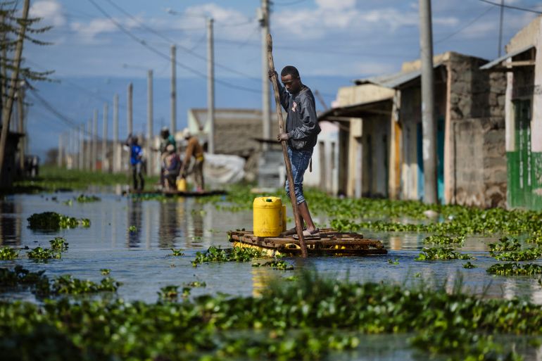 afp_691f0ee9e2d9-1763643113 Residents use push poles to manuever their makeshift rafts over a flooded access road to their residential blocks at Kohoto estate in Naivasha on November 17, 2025.