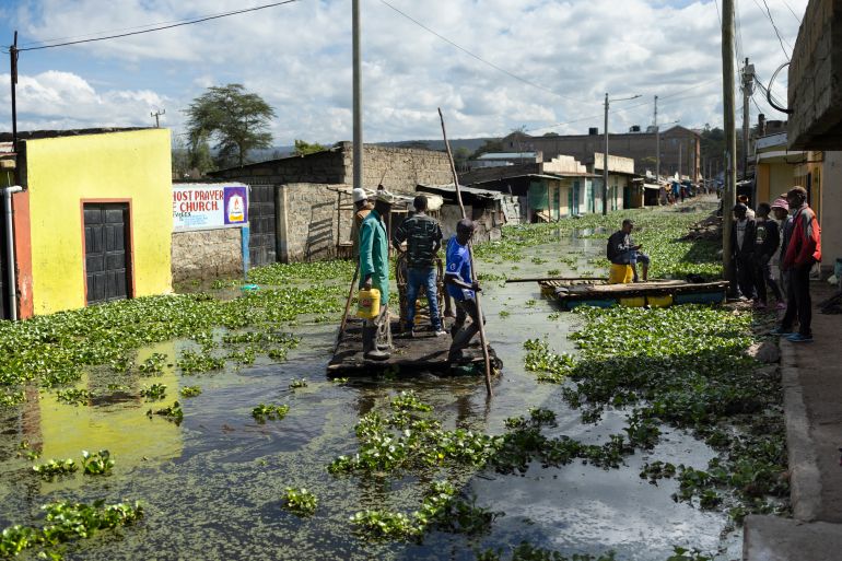 afp_691f0efc64a6-1763643132 Residents use push poles to manuever their makeshift rafts over a flooded access road to their residential blocks at Kohoto estate in Naivasha on November 17, 2025.