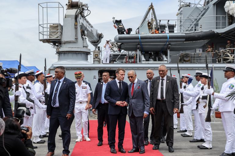 France’s President Emmanuel Macron (CL) and Mauritius Prime Minister Navin Ramgoolam (CR) disembark the Champlain vessel in the harbour near Port Louis on November 21, 2025. (Photo by Ludovic MARIN / AFP)