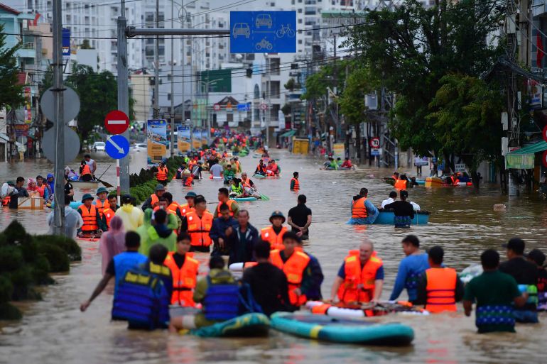afp_692167e631ab-1763796966 TOPSHOT - This photo taken on November 20, 2025 shows people wading through floodwaters in Nha Trang in Vietnam's coastal province of Khanh Hoa.