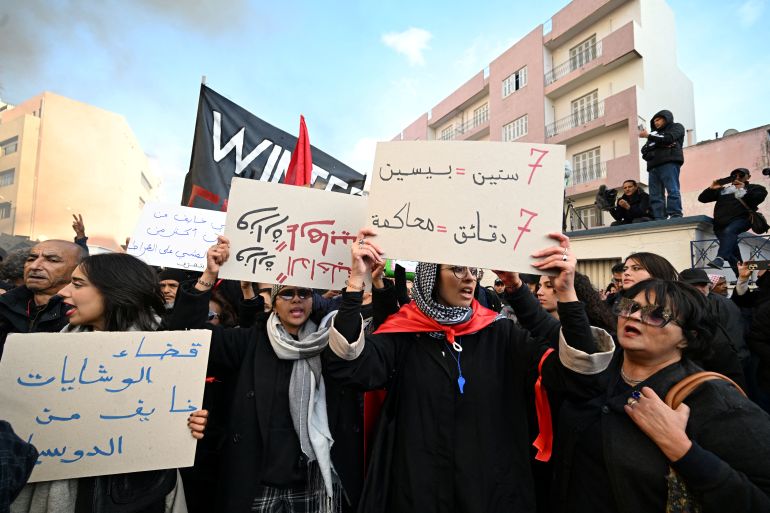 afp_6922088dc8c5-1763838093 Tunisians hold up placards as they demonstrate in a protest dubbed 'March Against Injustice' led by the opposition and the civil society against the Tunisian president's regime, in Tunis on November 22, 2025.
